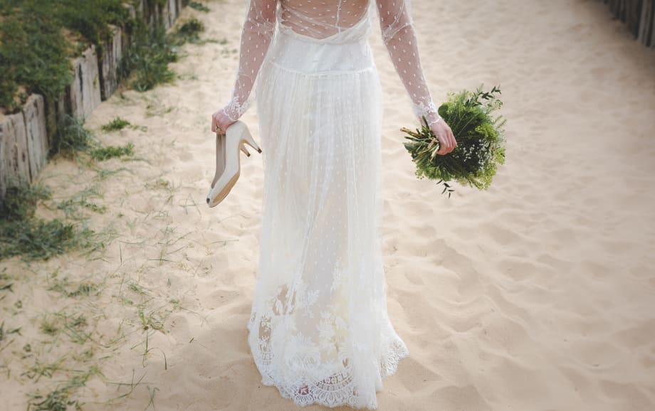 Bride walking on sand